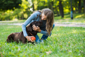 Frauchen spielt mit Hund im Park